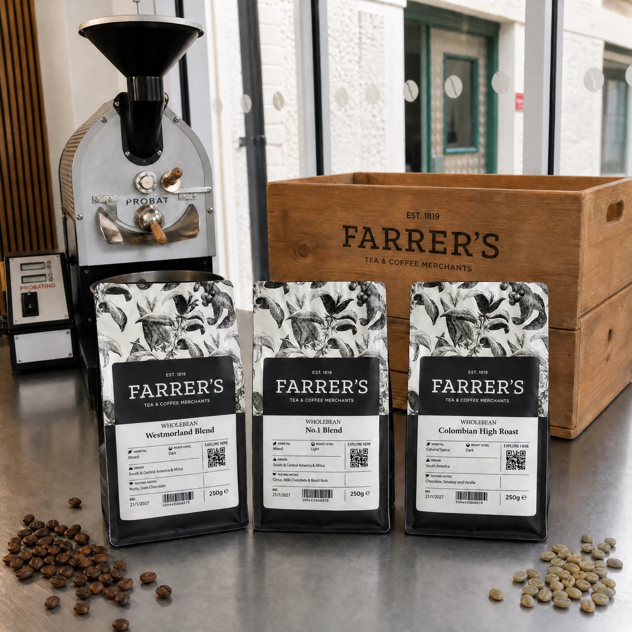 Westmorland Blend, No.1 Blend and Colombian High Roast beside the Farrers miniature roaster and wooden crate
