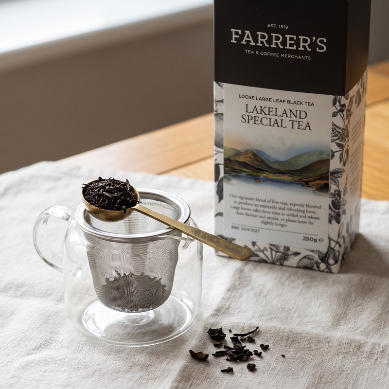 Loose Lakeland Special black tea measured into a clear infuser with a brass caddy spoon